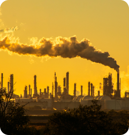 Factory smoke across a yellow sky at sunrise