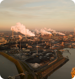 An image of factories with smoke coming out of their chimneys