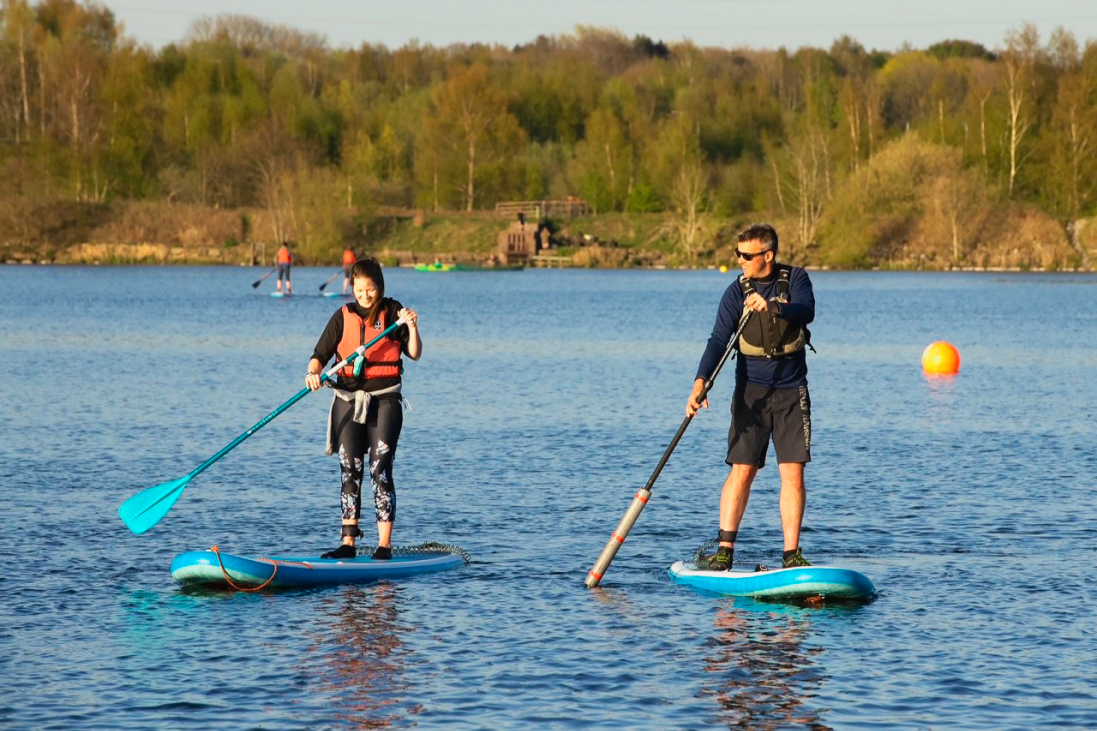 Two people paddle boarding at Scotman's Flash in the sun